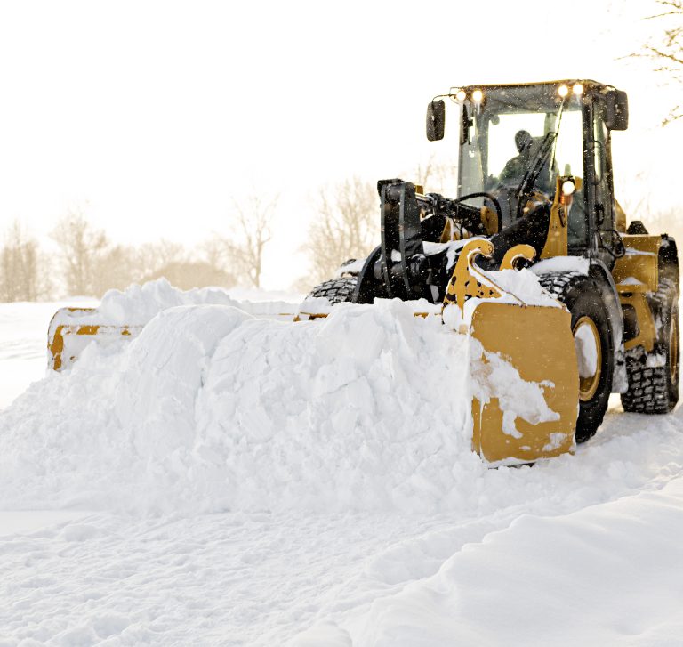 Snow plow clearing a snowy landscape.