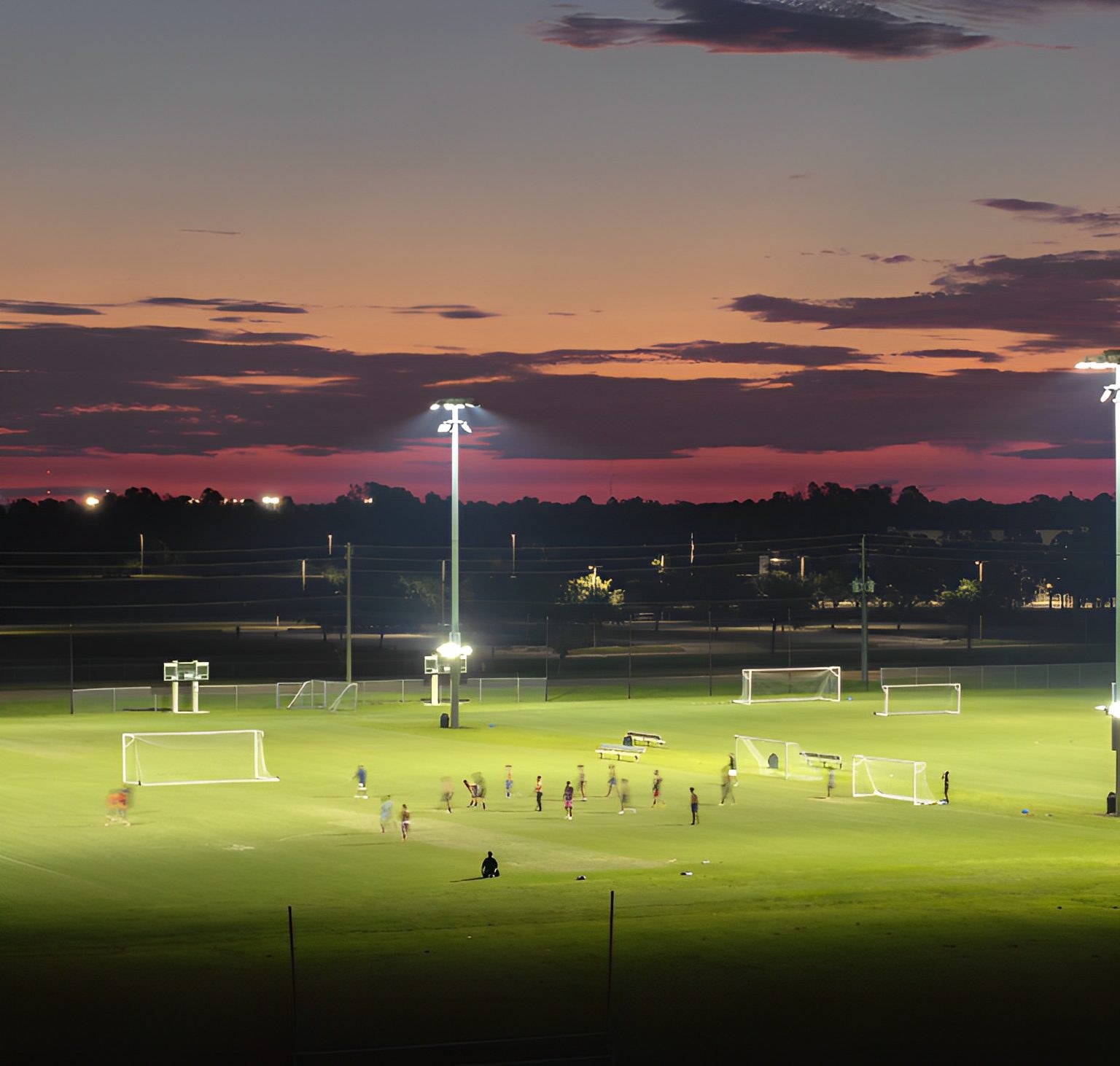 Soccer game under twilight sky.