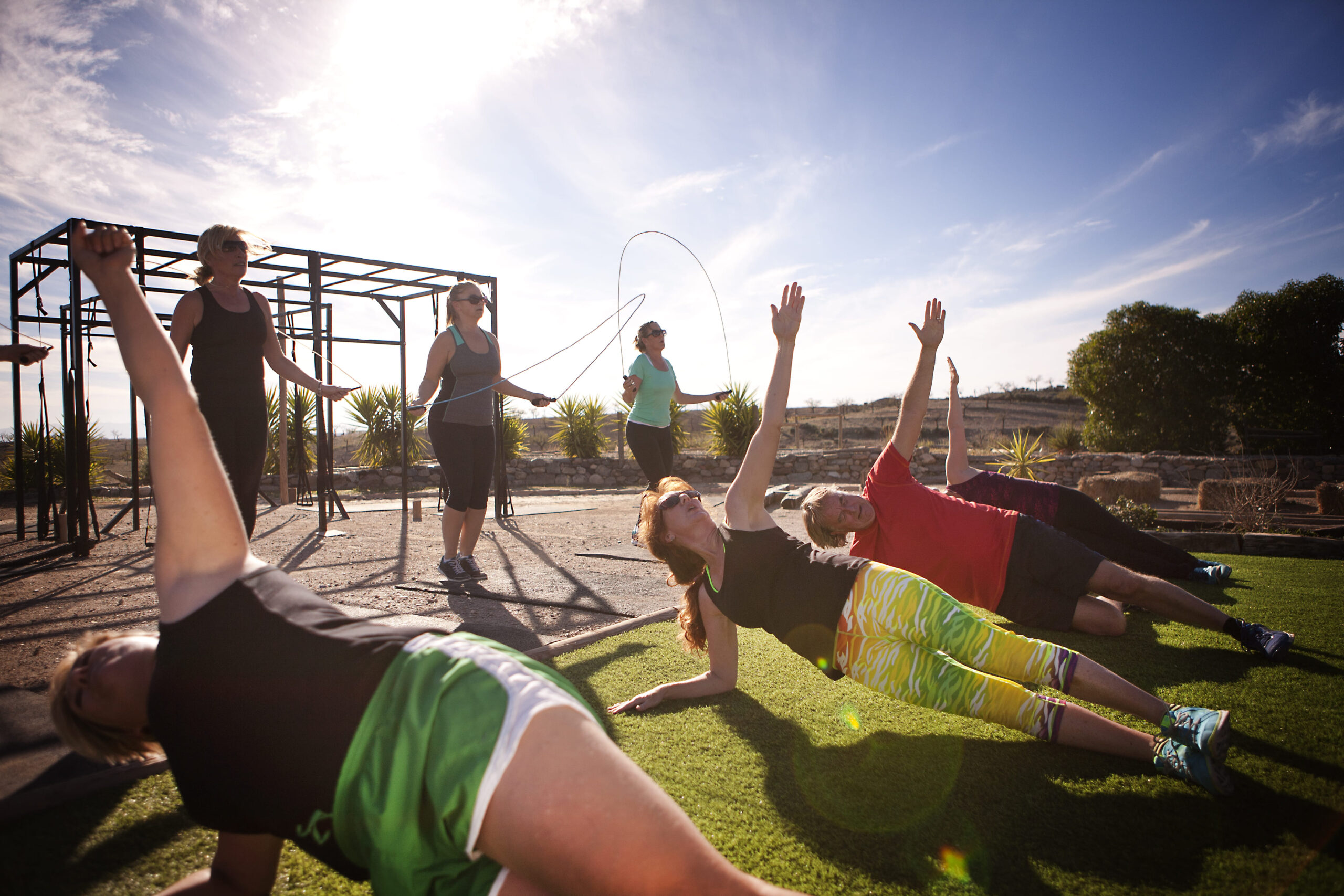 A group of people doing various exercises on the grass.